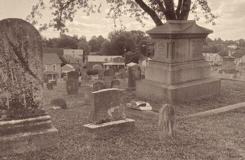 A sepia toned photograph of a cemetery with headstones of all sizes