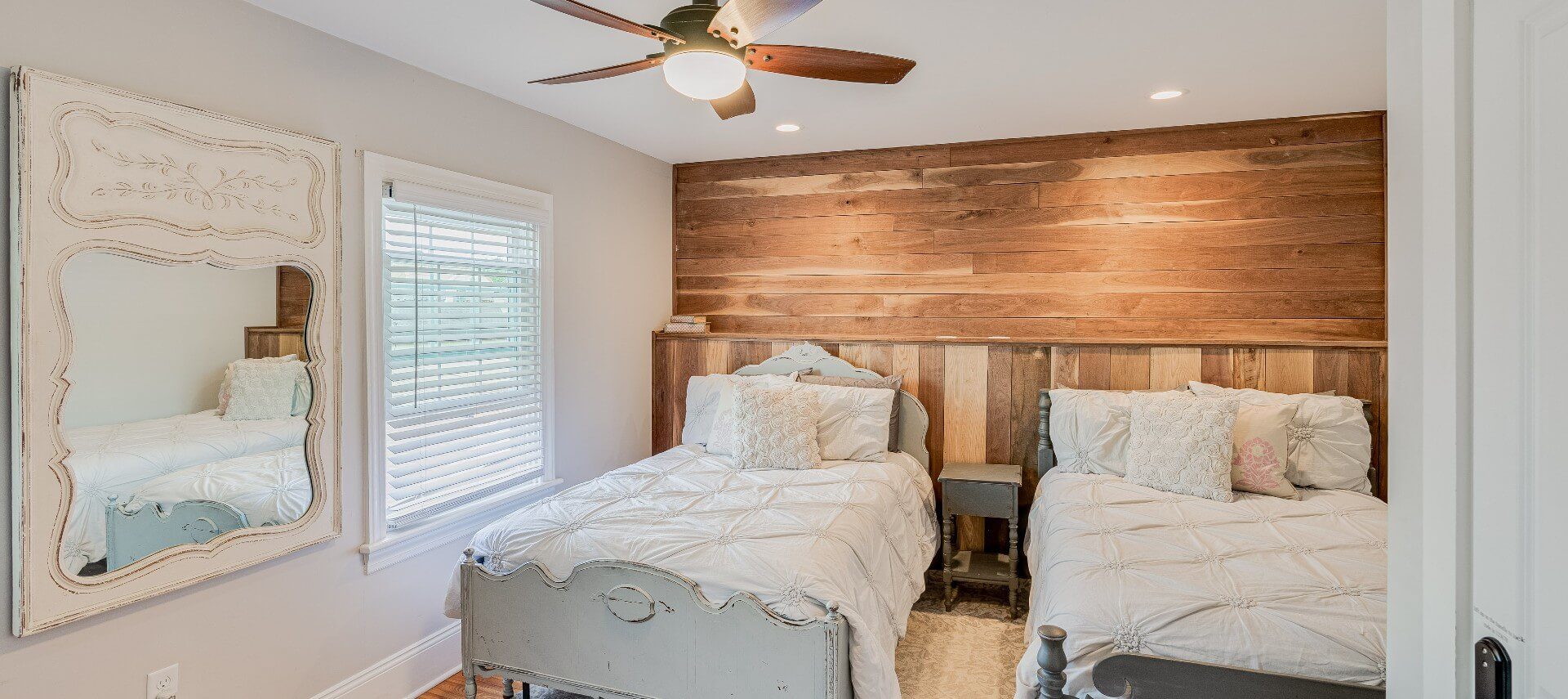 Bedroom with two full size beds in front of a wood feature wall
