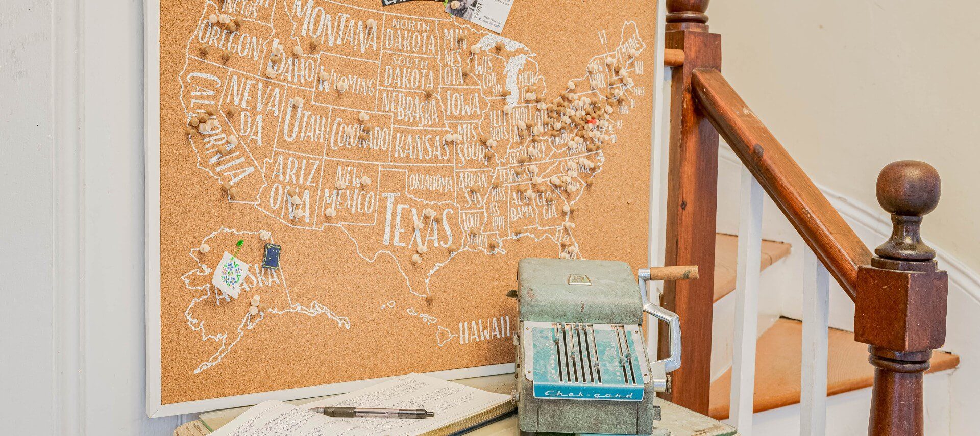 Large cork board map of the United States full of various pins over a desk